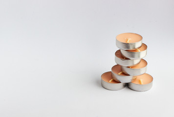 New small round wax candles on a white and gray background. Colored scented Spa candles. Minimal design.