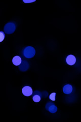 Lights blue blurred bokeh on black background from a small led lamp in a party.