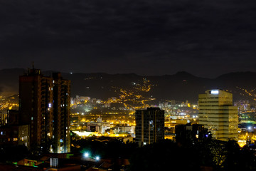 medellin, colombia. View of the night city. High buildings among the mountains. Yellow illumination