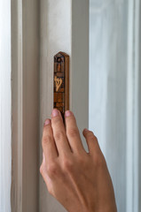 Girl touches wooden mezuzah in Tel Aviv