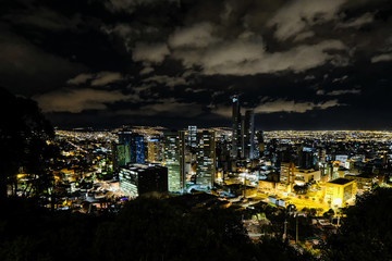 View of the night city with high buildings. Bogota, Colombia. A bit cloudy.