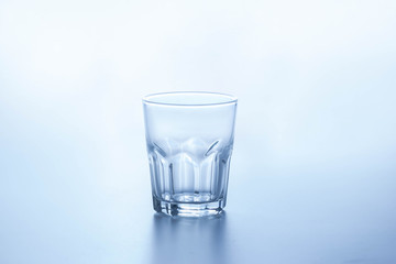 Clear water glass placed on a bright background.