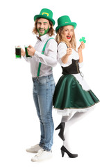 Young couple with beer on white background. St. Patrick's Day celebration