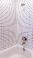 Vertical frame Modern tiled white bathtub with shower bright interior