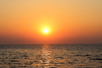 Beautiful burning yellow sunset at Jomtien beach Pattaya Thailand with silhouettes in the foreground 