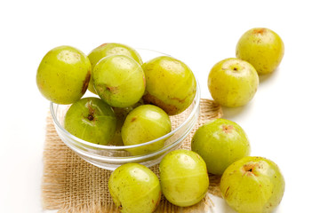 Fresh Indian gooseberry in glass bowl  on wooden board 