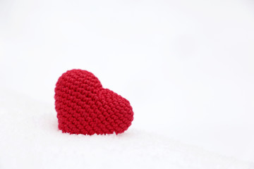Valentine's day, red knitted heart in the snow. Background for romantic event, celebration or winter weather 