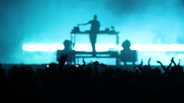 Blurred background of DJ playing music on mixer at a lifestyle rock concert concept party, light effects in dance club with colorful blur background