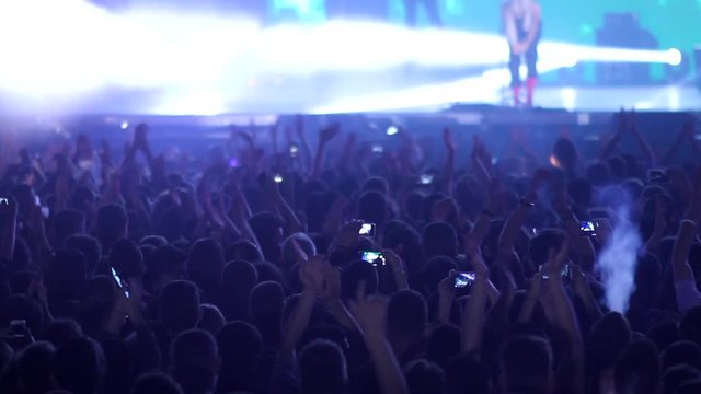 Crowd applause concert stage on green neon lights during music festival with preferred band performing favorite songs 