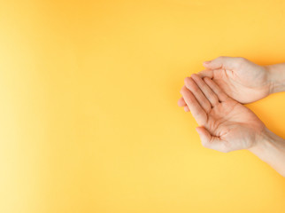 Naklejka premium The protection and security of the person. Hands palms up. Male arms crossed. Bright yellow background.