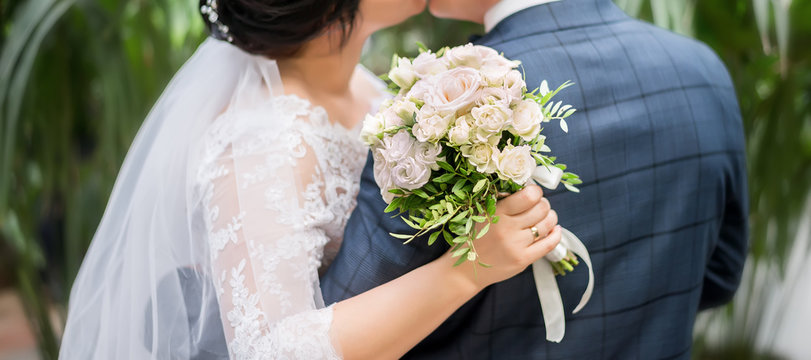 bride and groom holding beautiful wedding bouquet of flowers
