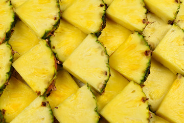 Pineapple juicy yellow slices background. Top view.