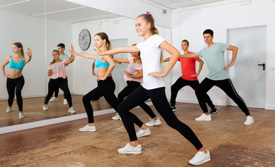 Fototapeta na wymiar Teenagers exercising with coach in choreography class