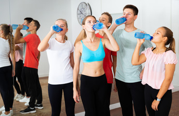 Fototapeta na wymiar Teenagers drinking water in choreography class