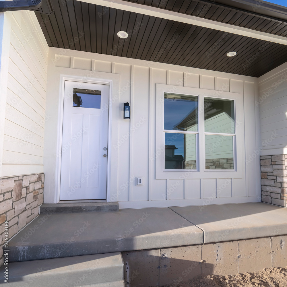 Wall mural Square frame Entrance door to a white timber clad home