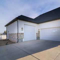 Square frame Two garages with paved forecourt and white doors © Jason
