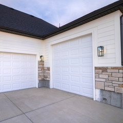 Square Two garage doors sharing a paved forecourt - obrazy, fototapety, plakaty