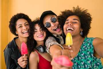 Multi-ethnic group of friends enjoying summertime while eating ice cream.