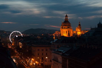 Night St. Stephen's Basilica and Ferris wheel illuminated. Pest district in Budapest, Hungary  