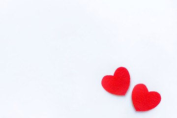 Two red felt hearts on a white background. Valentine's day symbol, holiday concept. Top view with copy space for text.