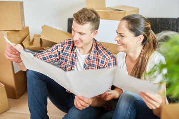 Couple with blueprint when planning house construction