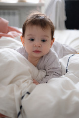 Little cute infant baby portrait in gender neutral clothes smiling