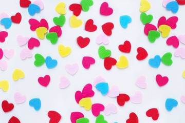 Background Colored small hearts on white. The concept of Valentine's Day, love, color therapy. Top view, flat lay.