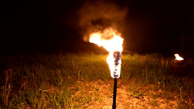 Three torches burn in the dark. Close-up. Slow motion, rotation. Low key