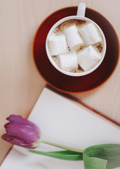 Fresh tulips with book and cup of coffee. Spring flowers and a cup of coffee with book, spring concept. top view. flatlay