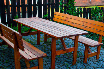 Fototapeta na wymiar Wooden table with two benches in a garden of a country house. Relaxing time