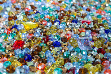 Mix of shining multicolored faceted glass beads for jewelry, background.