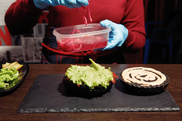 Woman cook makes a hamburger.