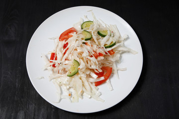 Plate with salad on the table.