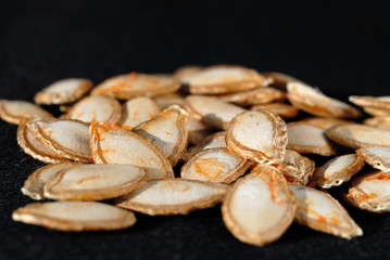 Last year pumpkin seeds on a dark background closeup. Shallow depth of field