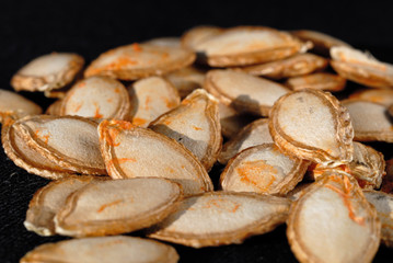 Last year pumpkin seeds on a dark background closeup. Shallow depth of field