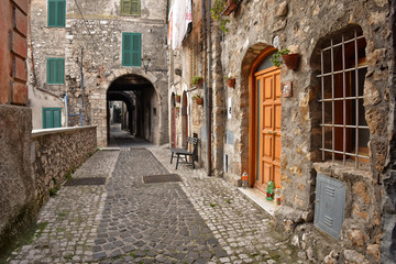 Fototapeta na wymiar Guarcino, Italy, 01/03/2020. An alley between the old houses of a medieval village.