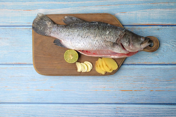 Barramundi or asian seabass fish with ginger,garlic,and key lime over the wooden cutting board.