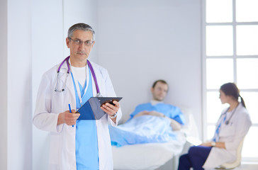 Doctor holding folder in front of a patient and a doctor