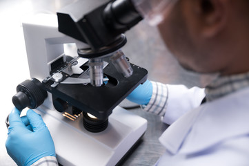 Young scientist working with a microscope in a laboratory. Young scientist doing some research.