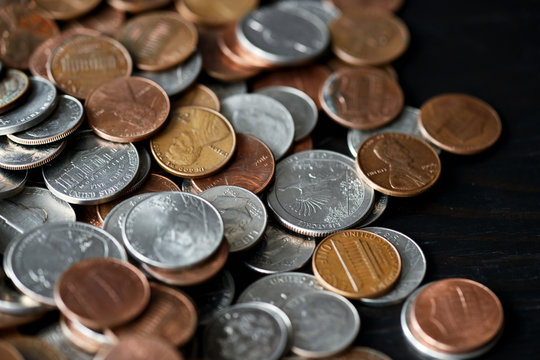 American cents coins are scattered on a black wooden surface. Money background