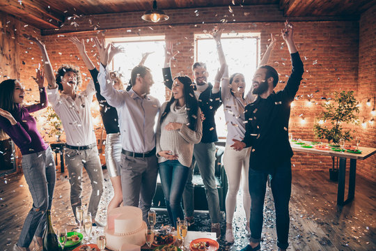Photo of group amazing friends throwing confetti surprise baby party meeting future parents big cake champagne snacks on table formalwear restaurant indoors
