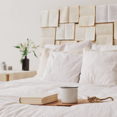 Fototapeta na wymiar Spring still life. Breakfast in bed. White bedroom. Sweet home. Books and coffee cup. flat lay