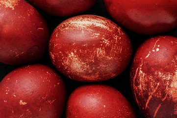Easter eggs painted in monochrome style close up isolated on black , in red brick color with...