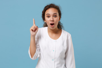 African american doctor woman isolated on blue background. Female doctor in white medical gown holding index finger up with new idea. Healthcare personnel health medicine concept. Mock up copy space.