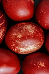 Easter eggs painted in monochrome style close up isolated on black , in red brick color with stains, scuffs, scratches. handmade painted eggs. Flat lay