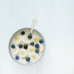 Healthy breakfast berry smoothie bowl topped with banana, granola, Blueberries and chia seeds with copy space