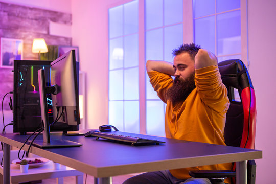 Bearded gamer streaching before a streaming seassion