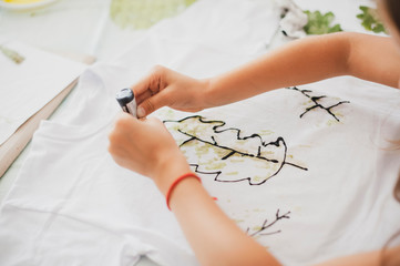 a child decorates a t-shirt