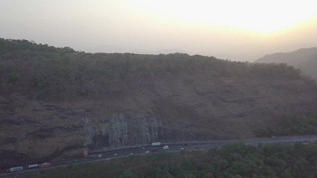 LTR Pan of Traffic along Mumbai Pune Expressway at Sunset Illustrating Pollution in Maharashtra, India