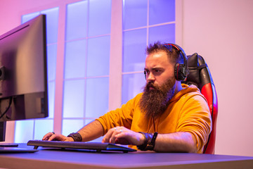 Professional gamer with long beard in front of powerful gaming rig © DC Studio